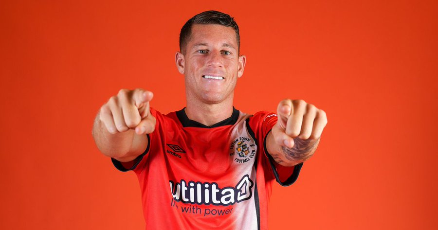  Ross Barkley points at the camera while posing in a Luton Town football shirt.